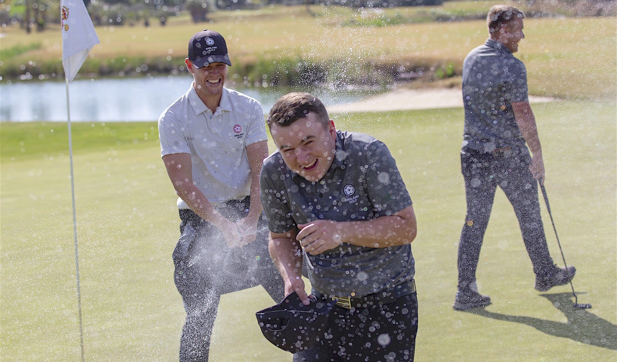 Spanish Amateur champion John Gough is doused in champagne by his England team-mate Callan Barrow