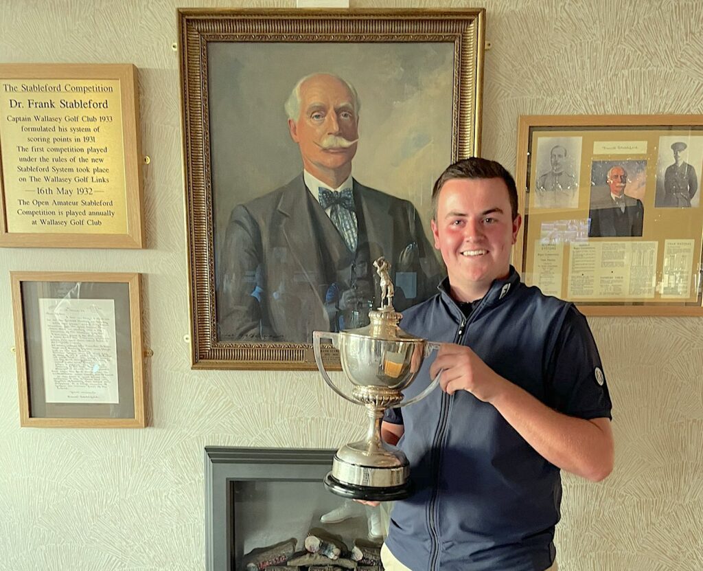 Champion Andrew Haswell in front of the Frank Stableford portrait at Wallasey Golf Club